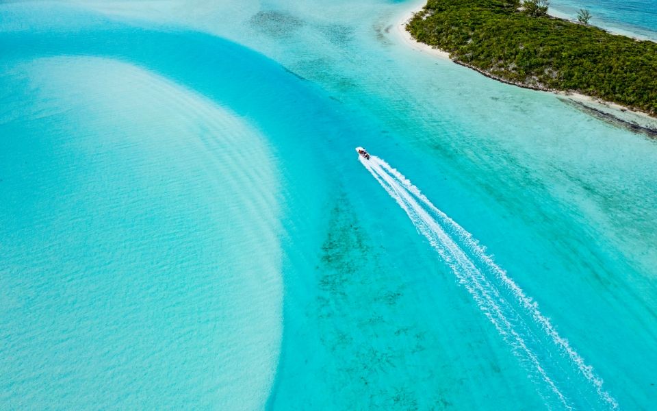 a drone shot of an island in a turquoise sea