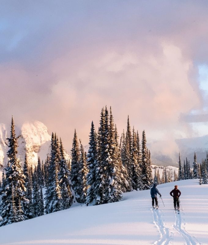 two people walking across fresh snow